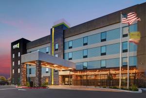 特雷西Home2 Suites By Hilton Tracy, Ca的一座前面有美国国旗的建筑