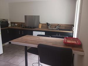 cocina con mesa de madera y algunas sillas en Loue appartement duplex de 90m2 refait à neuf, en Villefort