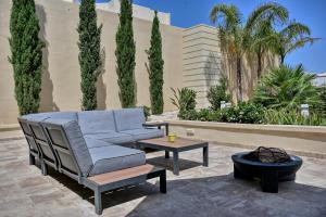 a patio with a couch and a table and trees at Ta Benna Villa in Għajnsielem