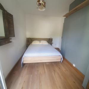 Cama pequeña en habitación con suelo de madera en Appartement rez de jardin proche du centre ville de sarzeau en Sarzeau
