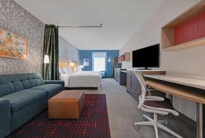 特雷西Home2 Suites By Hilton Tracy, Ca的配有沙发和床的酒店房间