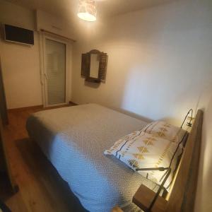 a bedroom with a bed in a room with a window at Appartement rez de jardin proche du centre ville de sarzeau in Sarzeau