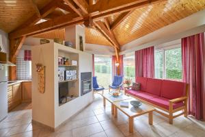 - un salon avec un canapé rouge et une table dans l'établissement FranceComfort - L'Espinet, à Quillan