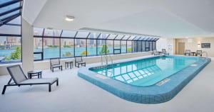 a large swimming pool in a building with windows at DoubleTree by Hilton Windsor, ON in Windsor