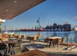 a patio with tables and chairs and a view of the water at Canopy By Hilton Baltimore Harbor Point - Newly Built in Baltimore