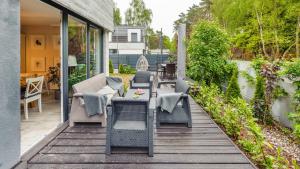 a patio with chairs and tables on a deck at Apartamenty Sun & Snow Łukęcin in Łukęcin