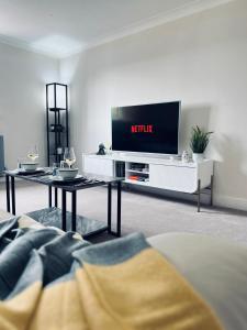 En tv och/eller ett underhållningssystem på Deluxe 2 Bedroom Apartment