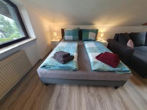 ein Schlafzimmer mit einem großen Bett und einem Sofa in der Unterkunft Ferienhaus-Schönwald, 2 Schlafzimmer, Küche, Dachterrasse, Balkon App24 in Schönwald