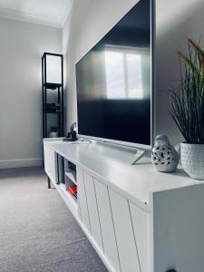 a white entertainment center with a flat screen tv on it at Deluxe 2 Bedroom Apartment in Sheffield