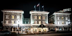 two buildings with flags on top of them at night at The Peery Salt Lake City Downtown, Tapestry Collection by Hilton in Salt Lake City