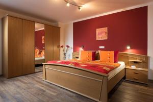 a bedroom with a large bed with a red wall at Ferienweingut Andrae-Goebel in Ernst