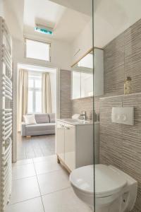 a bathroom with a toilet and a sink and a couch at Cozy Heaven in the lovely 2nd district of Vienna in Vienna