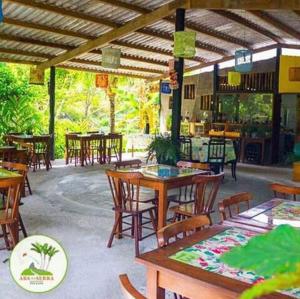 a restaurant with wooden tables and chairs and a lot of tables at Pousada Aba da Serra in São Joaquim do Monte