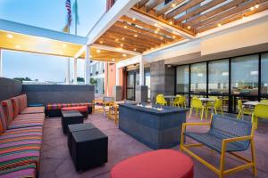 Home2 Suites by Hilton Roswell, NM في روزويل: مطعم يحتوي على كراسي ملونة وطاولات ونوافذ