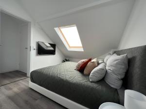 um quarto com uma cama com almofadas e uma janela em Premium FeWo - Blick auf Felsenkirche & Schloss - Traveller AWARD 2024 em Idar-Oberstein