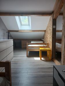 a room with a bed and a bench in a attic at Loue appartement duplex de 90m2 refait à neuf in Villefort