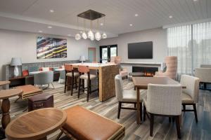 a restaurant with tables and chairs and a fireplace at Hampton Inn Boston Logan Airport Chelsea in Chelsea