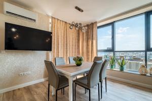 a dining room with a table and chairs and a large window at Metalex Garden 2bdrm Luxury Apartment in Varna City