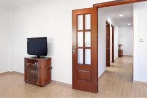 a room with a tv and a hallway with a door at Paseo Larios Torre del Mar in Torre del Mar