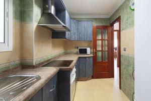 a kitchen with a sink and a microwave at Paseo Larios Torre del Mar in Torre del Mar