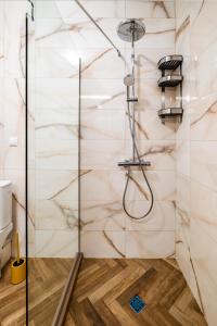 a shower in a bathroom with marble walls at Metalex Garden 2bdrm Luxury Apartment in Varna City