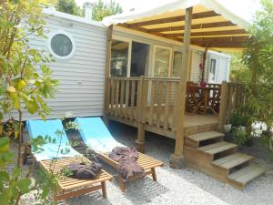 una casa pequeña con porche, hamaca y terraza en Vic's Land Holidays, en Grimaud
