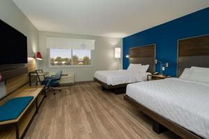 a hotel room with two beds and a flat screen tv at Tru By Hilton Columbus Airport in Columbus