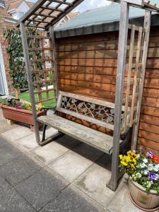 a wooden bench sitting under a pergola at 31 Elwyn Snug in March