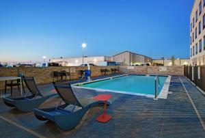 a pool with chairs and a table on a rooftop at Hampton Inn Midland South, Tx in Midland