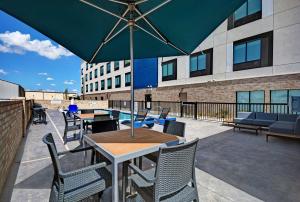 a patio with tables and chairs and an umbrella at Hampton Inn Midland South, Tx in Midland