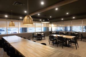 um restaurante com mesas e cadeiras de madeira e janelas em DoubleTree by Hilton Calgary North em Calgary