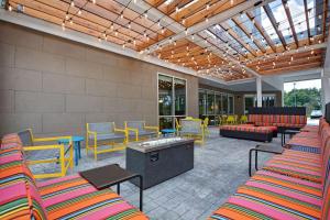 un patio con sillas y mesas coloridas y un sofá en Home2 Suites By Hilton Fort Mill, Sc en Fort Mill