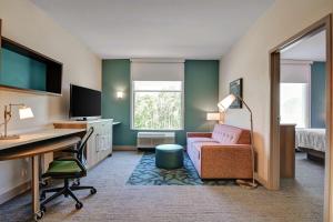 Home2 Suites By Hilton Fort Mill, Sc في فورت ميل: غرفة في الفندق مع مكتب وسرير