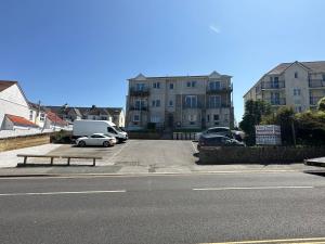 a parking lot with cars parked in front of buildings at Eton Court Apartments in Newquay