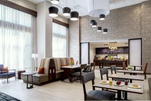 a restaurant with tables and chairs and a kitchen at Hampton Inn & Suites Indio, Ca in Indio