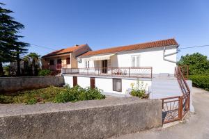 a white house with a balcony in front of it at Apartment Dunato in Polje