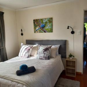 a bedroom with a bed with a blue hat on it at Loeries Nest in Jeffreys Bay