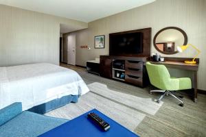 a hotel room with a bed and a desk and a television at Hampton Inn & Suites Indio, Ca in Indio
