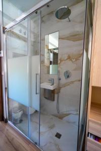 a bathroom with a shower with a sink and a mirror at alojamiento cuatro estaciones in La Pola de Gordón