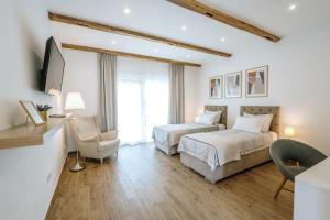 1 dormitorio con 2 camas, TV y silla en Old Town Zagreb Airport, en Velika Gorica