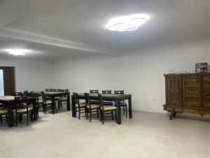 a dining room with black tables and chairs at Bingyó Vendégház in Lupeni