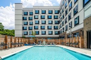 a swimming pool in front of a building at Hampton Inn & Suites Raleigh Midtown, NC in Raleigh