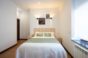 una camera da letto con un grande letto in una stanza bianca di alojamiento cuatro estaciones a La Pola de Gordón