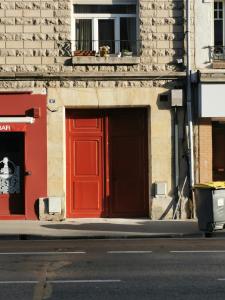 una porta rossa sul lato di un edificio di Très bel appartement climatisé à deux pas de la cathédrale a Reims