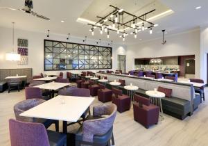森林湖Homewood Suites By Hilton Irvine Spectrum Lake Forest的有桌椅和酒吧的餐厅