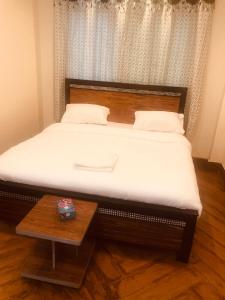 アユビアにあるHotel 99#のベッド(木製のヘッドボード、テーブル付)