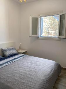 a bedroom with a bed and a window at Syrona in Posidhonía +21 photos
