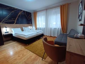 a hotel room with a bed and a couch at Pension Amelie in Mörbisch am See