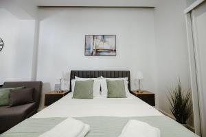 ein Schlafzimmer mit einem großen Bett und einem Sofa in der Unterkunft M & N Guesthouse in Volos