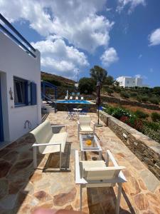 a group of white chairs and a table on a patio at Syrona in Posidhonía